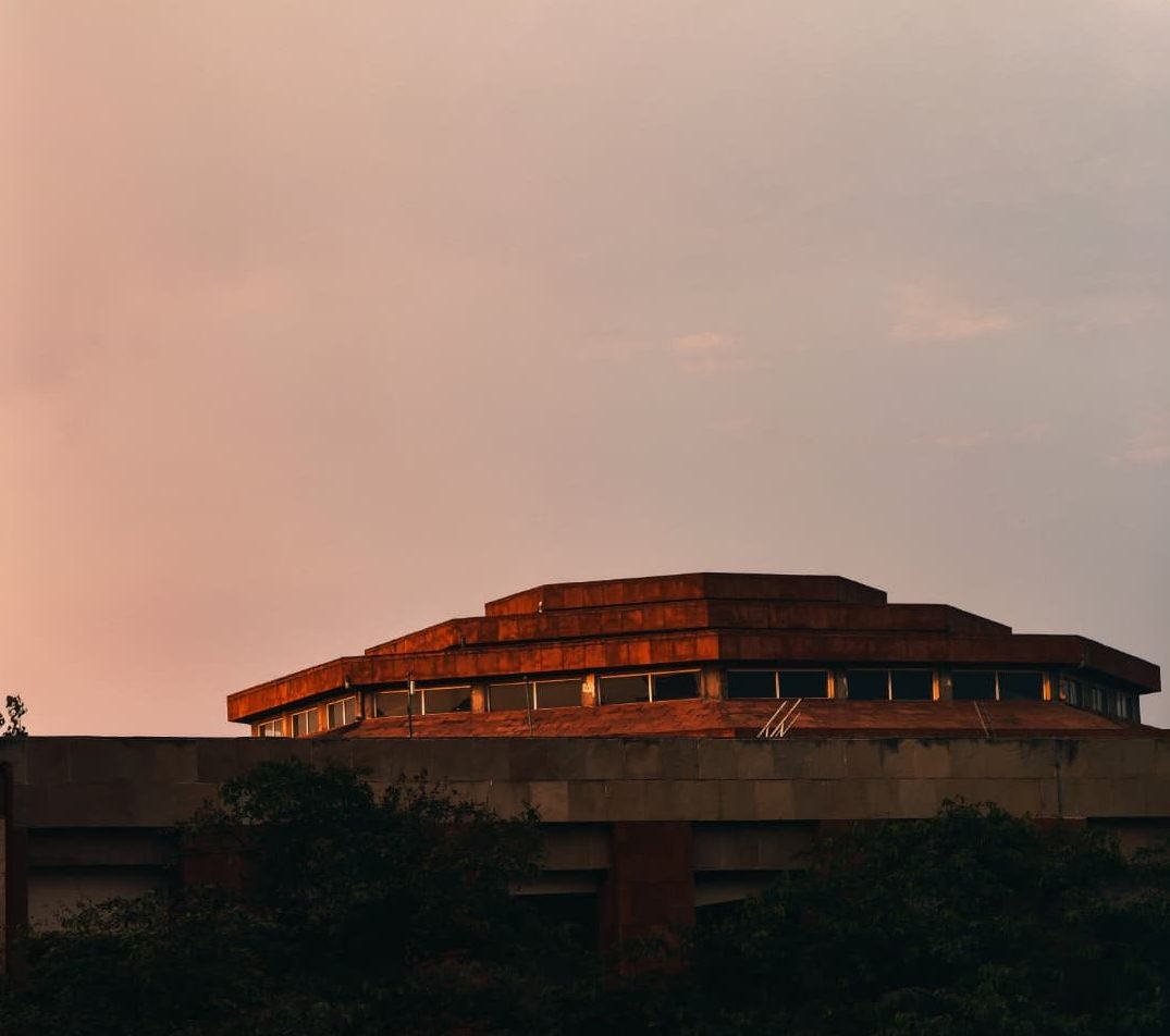 The auditorium dome glowing copper against a pink evening sky